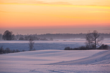 sunny, snowy winter day in the countryside at sunset