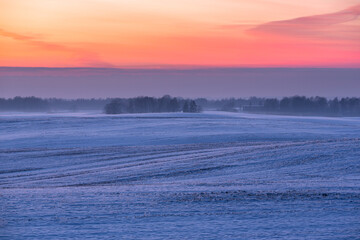 sunny, snowy winter day in the countryside at sunset