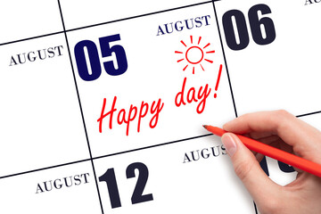 Hand writing the text HAPPY DAY and drawing the sun on the calendar date August 5