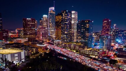 Urban aerial view of busy downtown Los Angeles California in USA at night with freeway traffic time lapse. - Powered by Adobe
