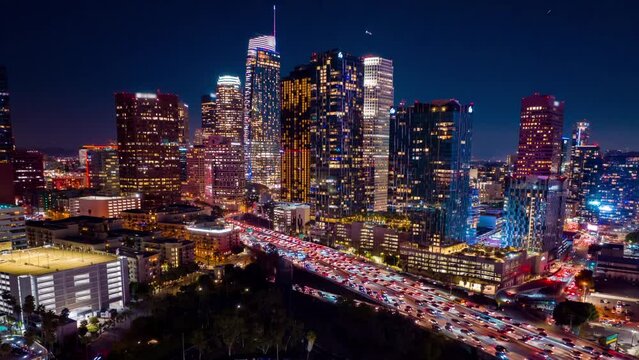 Urban aerial view of busy downtown Los Angeles California in USA at night with freeway traffic time lapse.