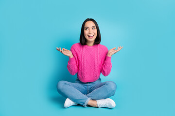 Full length photo of adorable excited lady wear pink pullover looking empty space isolated blue...