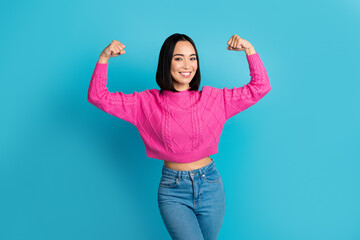 Portrait of cheerful strong lady toothy smile arms show flex biceps crop sweater isolated on blue...
