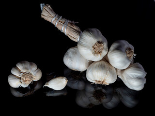 garlic in a bunch on a black background in reflection