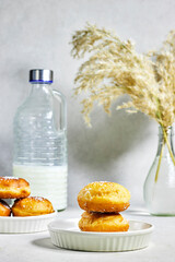homemade Algeria Donut with apricot jam and powdered with sugar, bottle of milk and reeds vase