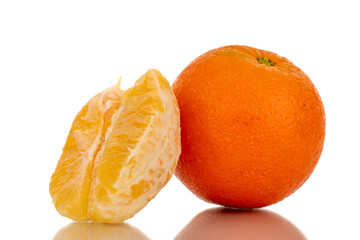 One unpeeled orange and half of a peeled orange, macro, isolated on white background.