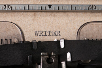 The word 'WRITER' embossed on gray paper using an old typewriter.	