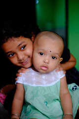 South asian little sisters are playing with each other, indoor family photo, friends playing with doll ,beautiful kids having fun