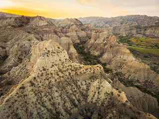 Surreal dramatic deserted earth landscape panorama with beautiful cliff formations and golden sunset background in Vashlovani national park. Travel Georgia destination.