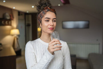portrait of woman young caucasian female drink glass of water at home
