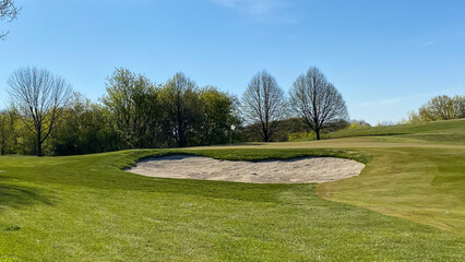 golf green and sand trap in the spring