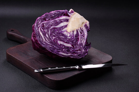 Fresh beautiful red cabbage with textured leaves on a dark concrete background
