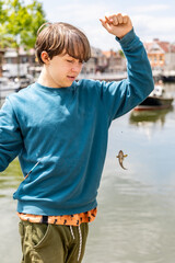 The boy caught a goby fish on a canal in Amsterdam