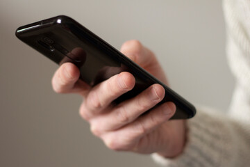 Smartphone in the hand of a man. Looks at the display. Internet search, message exchange. Video motion closeup