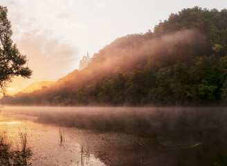 Beautiful landscape with morning fog at sunrise. Temple on chalk cliffs at dawn, over the river. Ukrainian landscape. River Siverskiy Donets, Sviatohirsk, Donetsk Region, Ukraine. 