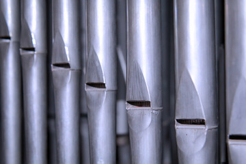 Viele Orgelpfeifen stehen nebeneinander in einer Orgel über einen Blasebalk.