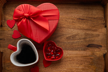Mug and red gift with ribbon bow on tray background for a Valentines Day,