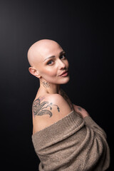 beautiful girl with alopecia and tattoo. dark background