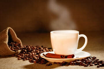 Coffee cup and coffee beans on a wooden table and sack background, Vintage color tone
