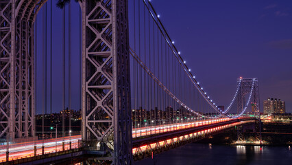 Light Trails from streaming rush hour traffic across the George Washington Bridge connecting North New Jersey to upper Manhattan at dusk