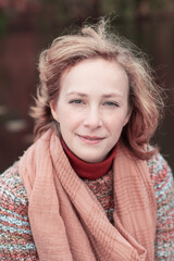 portrait of a young beautiful girl with developing hair in an autumn sweater