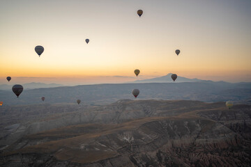 Views of Cappadocia from above, hot air balloons over the valley at dawn