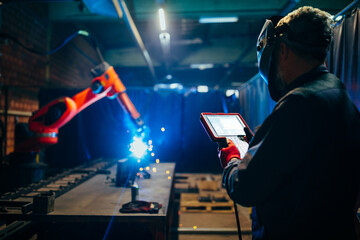 Engineer testing industrial robot welder