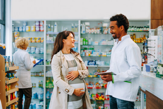 African American pharmacist with pregnant customer.