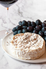 Camembert cheese served with grapes and red wine