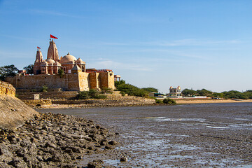 Koteshwar Mahadev Temple with Red pendant flying on top situated in Koteshwar Gujarat at the Kori Creek during low tide