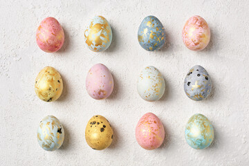 Decorated multicolor pastel Easter eggs with gold on white table. Flat lay geometric pattern. Happy Easter card.