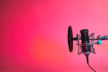 a microphone on on red and orange shade neon background with copy space.