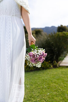 Vertical midsection of bride holding bouquet at outdoor wedding, copy space