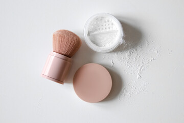 Powder, cosmetic brush on a light background. Loose powder.