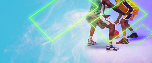 Low section of multiracial male players playing basketball by rectangle on blue background