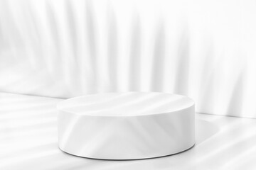 White round pedestal on a white background. Palm branches. Shadows from palm branches.