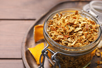 Tray with jar of dried orange zest seasoning on wooden table, closeup. Space for text