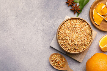 Bowl of dried orange zest seasoning, fresh fruits and anise on light grey table, flat lay. Space for text