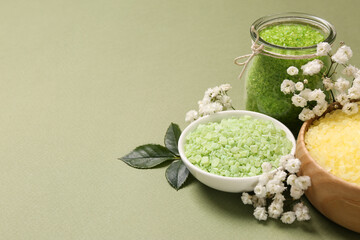 Sea salt and beautiful flowers on olive background. Space for text