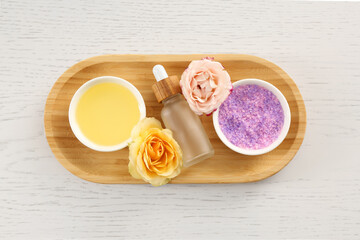 Fototapeta na wymiar Purple sea salt, beautiful flowers and different spa products on white wooden table, top view