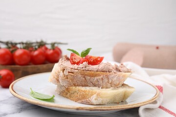 Delicious liverwurst sandwich with tomatoes and basil on white marble table, closeup