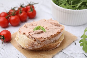 Fototapeta na wymiar Delicious liverwurst sandwich with basil on white textured table, closeup