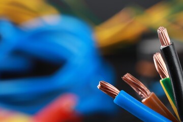 New colorful electrical wires on blurred background, closeup. Space for text