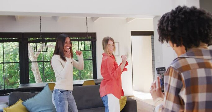 Happy diverse teenager girls friends dancing and making vlog at home, slow motion