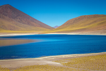 Salt lake, turquoise Laguna Miniques, volcanic landscape at sunrise, Atacama