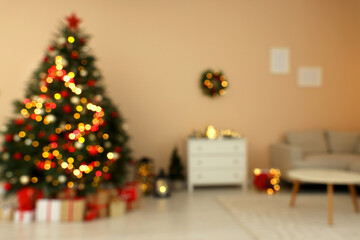 Blurred view of beautiful Christmas tree decorated with festive lights in stylish room. Interior design