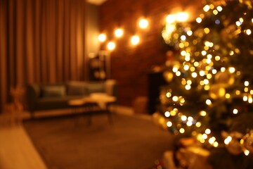 Blurred view of beautiful Christmas tree with lights in living room
