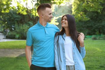 Obraz premium Affectionate happy young couple walking in park