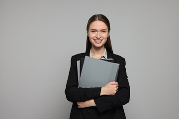 Portrait of beautiful young teacher on grey background