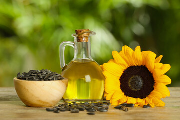 Sunflower cooking oil, seeds and yellow flower on wooden table outdoors